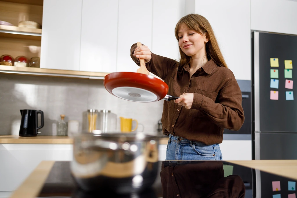 Sarah Jane Thompson in her kitchen, skillfully tossing food in a red pan, bringing an American classic recipe to life.