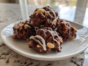 A stack of rich, chocolate crockpot peanut clusters drizzled with white chocolate on a white plate.