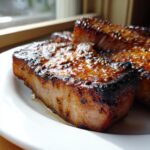 Close-up of thick, juicy pork chops glazed with a rich marinade, perfectly seared.