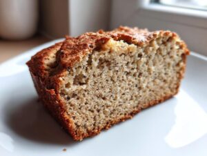 Close-up of a moist slice of Protein banana bread showing its dense, speckled crumb texture.