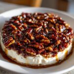 Close-up of a round pecan pie dip made with a creamy base and topped generously with glossy, caramelized pecans.