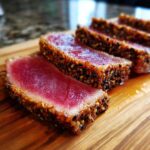 Slices of perfectly cooked Seared Ahi Tuna, featuring a bright red center and a thick sesame seed crust.