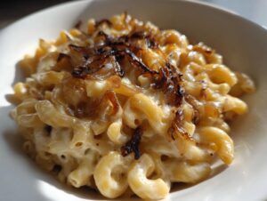Close-up of creamy french onion pasta featuring elbow macaroni coated in cheese sauce and topped with crispy caramelized onions.