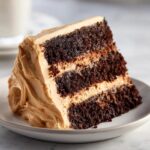 Close-up of a rich, dark chocolate slice of gingerbread latte cake layered with light brown coffee frosting.