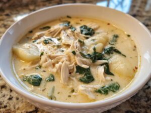 Close-up of a bowl of creamy Olive Garden Chicken Gnocchi Soup with shredded chicken and spinach.