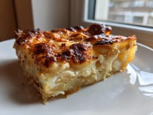 A hearty slice of potatoes au gratin showing creamy layers and a deeply browned, cheesy crust.