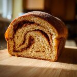 Cross-section of a rich pumpkin sourdough loaf showing a beautiful cinnamon swirl pattern inside.
