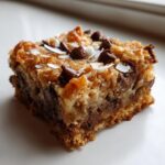 A single, thick square of magic cookie bars topped with chocolate chips and coconut flakes.