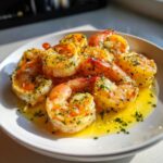 Close-up of juicy air fryer frozen shrimp coated in melted butter, garlic, and parsley.