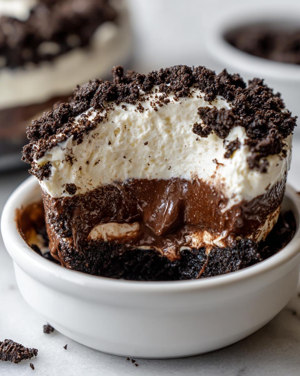 Cross-section of a Baileys Chocolate Cheesecake Trifle showing layers of chocolate crust, rich chocolate filling, and whipped topping with cookie crumbs.