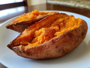 Close-up of two halves of a baked sweet potato, showing the fluffy orange interior seasoned with spices.