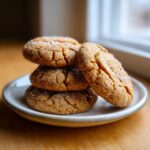 A stack of four chewy brown butter sugar cookies, heavily coated in sparkling sugar crystals.