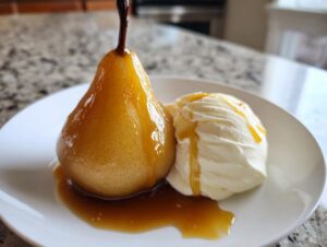 A single, glistening poached pears served with a scoop of vanilla ice cream and caramel sauce.