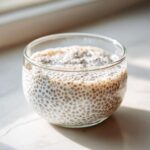 Close-up of creamy coconut chia pudding texture in a clear glass, ready to eat.