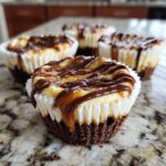 Close-up of one of the amazing cookie butter cheesecake cups topped with caramel and chocolate drizzle.