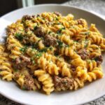 Close-up of creamy beef pasta made with fusilli noodles, seasoned ground beef, and topped with fresh parsley.