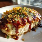 A thick cut of Fiesta Lime Chicken topped with melted white cheese, dark red sauce, crunchy toppings, and parsley.