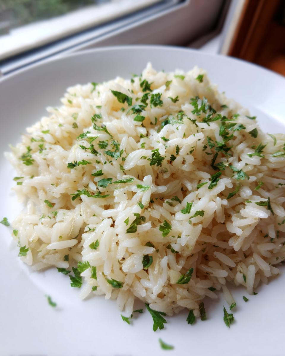A close-up of fluffy white rice pilaf garnished generously with chopped green parsley on a white plate.