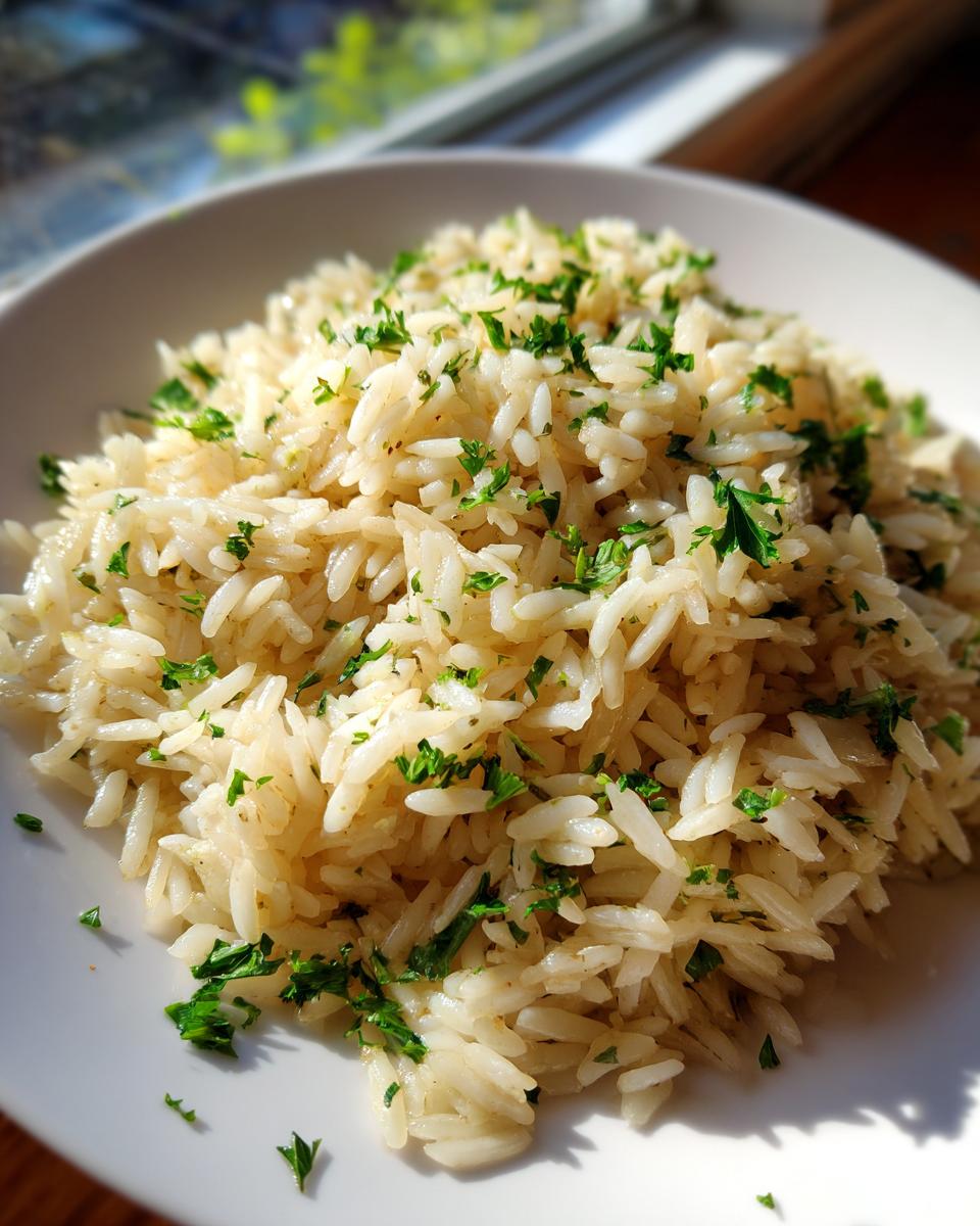 Close-up of fluffy rice pilaf served on a white plate, garnished generously with chopped fresh parsley.