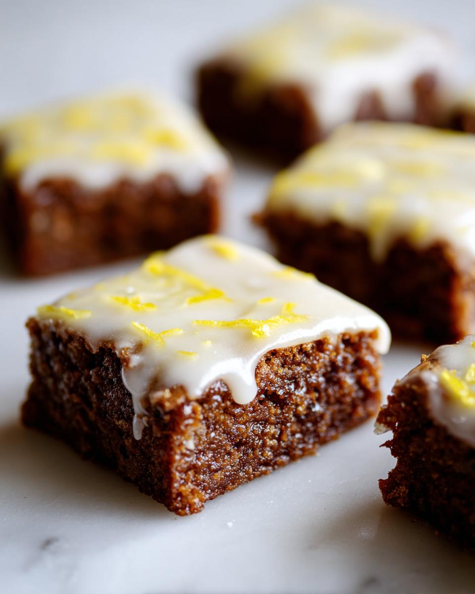 Close-up of a fudgy Lemon Brownies square topped with white glaze and bright yellow lemon zest.