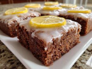 Close-up of fudgy Lemon Brownies squares, topped with white glaze and a thin lemon slice.