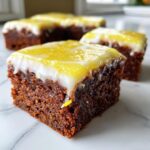 Close-up of a fudgy Lemon Brownies square topped with white icing and a bright yellow lemon glaze.