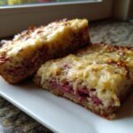 Two thick slices of homemade Reuben bake showing layers of corned beef, sauerkraut, and melted cheese topping.