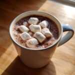 Close-up of a mug filled with rich homemade hot cocoa topped with fluffy white marshmallows.