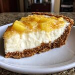 A close-up slice of rich, creamy Million Dollar Pie featuring a graham cracker crust and a bright pineapple topping.