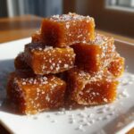 Close-up of a stack of rich, brown soft sea salt caramels generously sprinkled with coarse sea salt crystals.