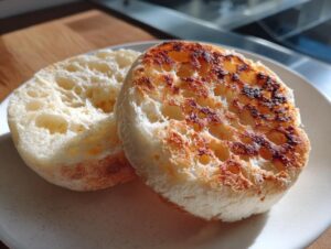 Two halves of a toasted english muffin showing the signature nooks and crannies texture.