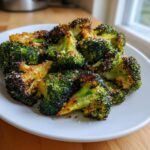 Close-up of perfectly crispy roasted broccoli florets sprinkled with Parmesan cheese.