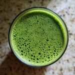 Overhead view of vibrant green matcha chia pudding topped with fine foam bubbles.